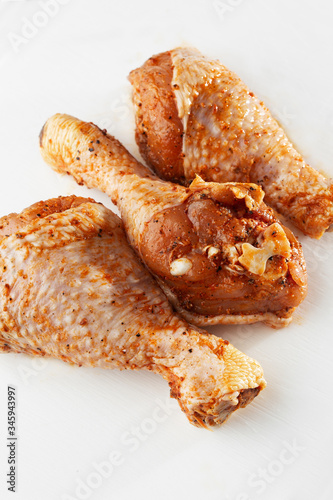 Raw drumsticks on white background. Chicken legs. Raw chicken marinated legs. Top view. Food Background. Cooking content. Uncooked meat. Meat shop concept.