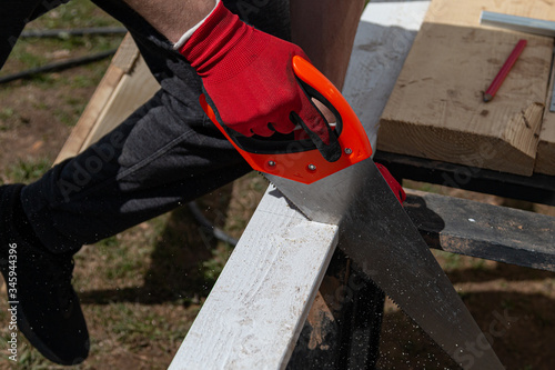 Sawing a wooden board with a hand saw