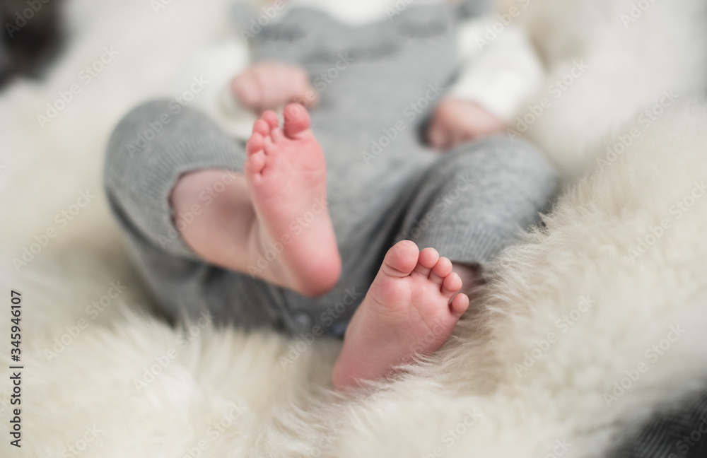 A beautiful soft delicate warm young baby foot photographed with a shallow depth of field. gentle calm colours and feel. baby care and well being. babies feet on a cream fur rug. A beautiful soft delicate warm young baby foot photographed with a shallow depth of field. gentle calm colours and feel. baby care and well being. babies feet on a cream fur rug.