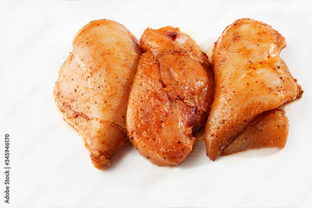 Marinated fillet isolated on a white background. Raw chicken breast fillets. top view with copy space. Flat lay composition with raw chicken breasts. Space for text. Meat shop.