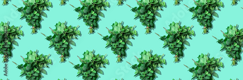 Bunches of peppermint leaves pattern on trendy green background. Top view. Copy space. Fresh mint herbs. Creative design, minimal flat lay concept. Vegan and vegetarian food