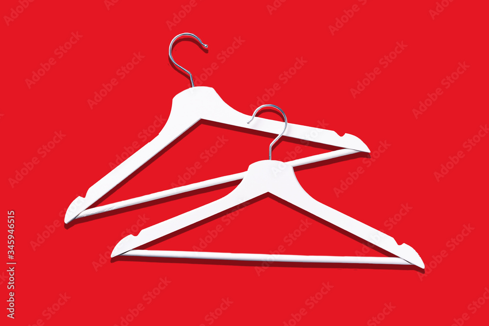 Top view of white clothes hanger on red background with copy space. Flat lay. Minimalism style. Creative layout. Fashion, store sale, shopping concept. Banner for feminine blog. Top view of white clothes hanger on red background with copy space. Flat lay. Minimalism style. Creative layout. Fashion, store sale, shopping concept. Banner for feminine blog.