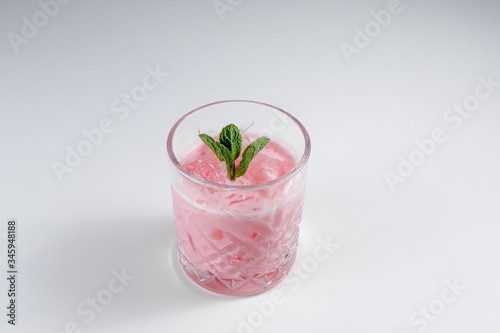Glass with tasty pink cocktail on a white background