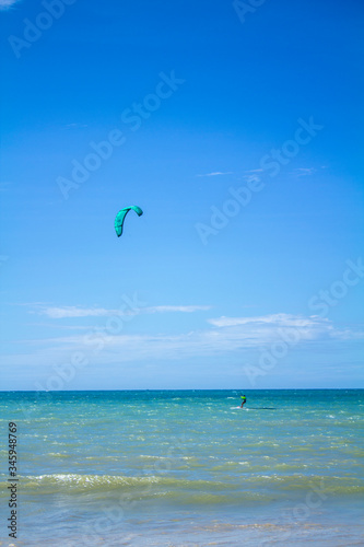 Tourist Beach, Cumbuco in Ceara, Northeast Brazil. Sunny day, weekend, beach holidays, hot summer. Man practicing kite surfing in the sea, doing sport. Sea and blue sky. Beautiful sunny day. Relaxing 