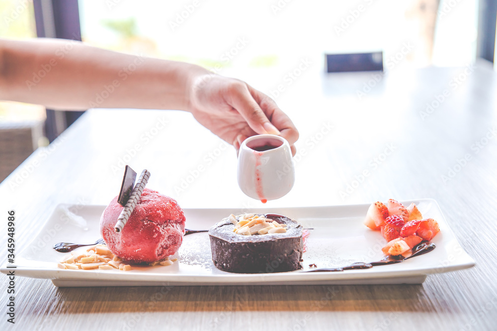 Close up the chocolate lava dessert with strawberry ice cream on white plate. Close up the chocolate lava dessert with strawberry ice cream on white plate.