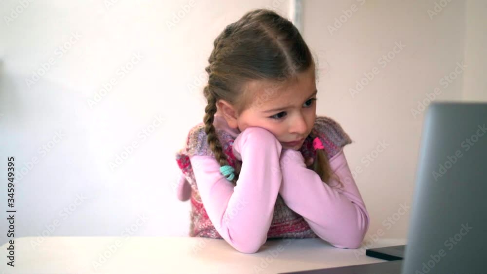 Little girl with laptop watching something. Studying online. Cartoons watching kid on laptop. Little girl with laptop watching something. Studying online. Cartoons watching kid on laptop.