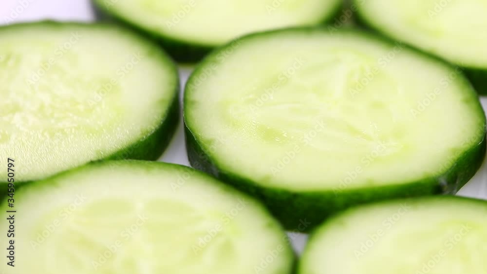 Sliced green cucumber slices rotate, spinning slowly in a circle, close up. Sliced green cucumber slices rotate, spinning slowly in a circle, close up.