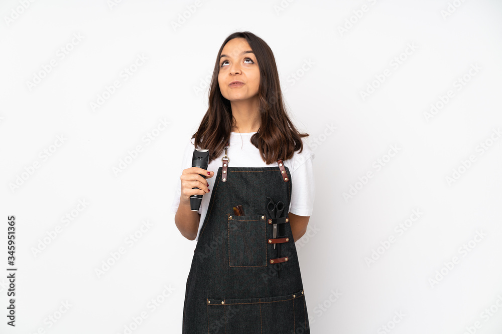 Young hairdresser woman isolated on white background and looking up Young hairdresser woman isolated on white background and looking up