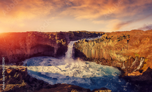 Colorful summer landscape of Iceland. Majestic Aldeyjarfoss waterfall with picturesque dramatic sky, during sunset. Scenic image of Icelandic nature. Popular travel and hiking destination