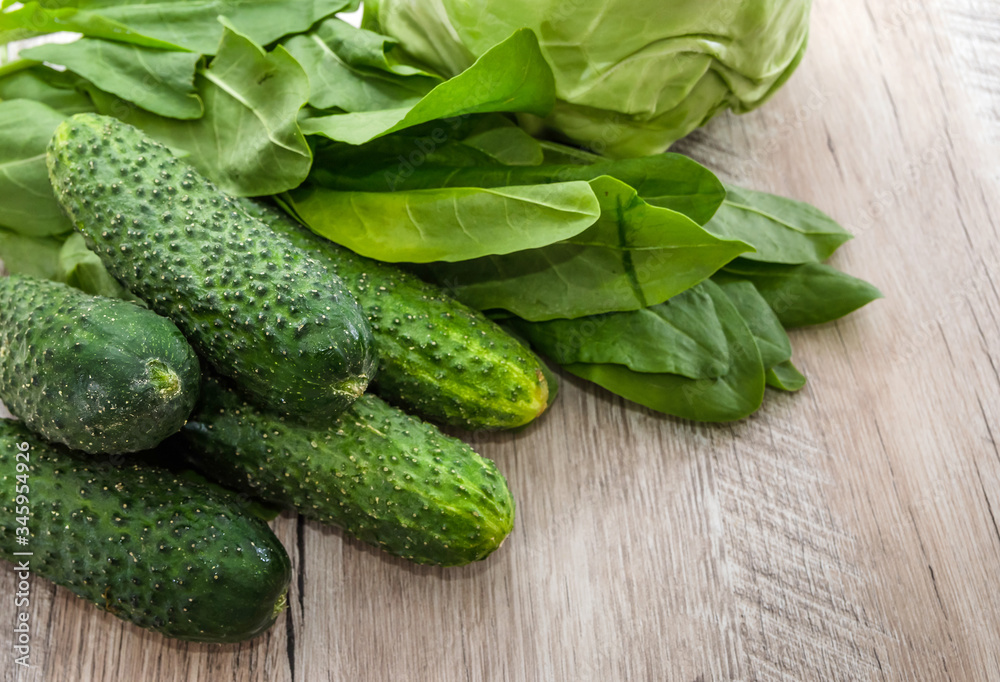 green vegetables on a wooden background. Cucumbers, cabbage and sorrel. green vegetables on a wooden background. Cucumbers, cabbage and sorrel.