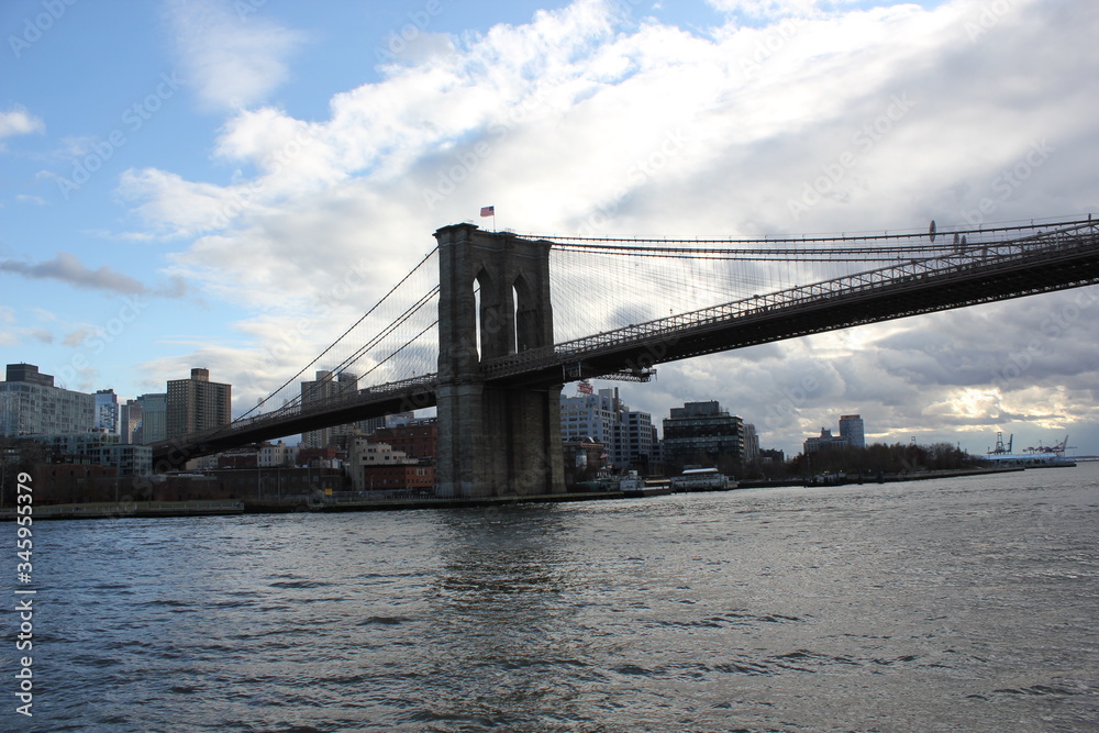 New york, USA - 20.12.2019: Brooklyn bridge in New York, Manhattan skyscrapers skyline behind across Hudson river at end of day New York, USA - stock photo