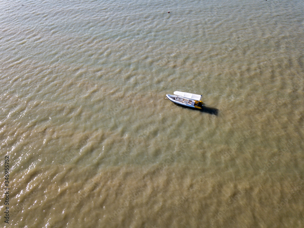 Fototapeta premium The drone captures a high angle view of inflatable boat moored in the Andaman sea.