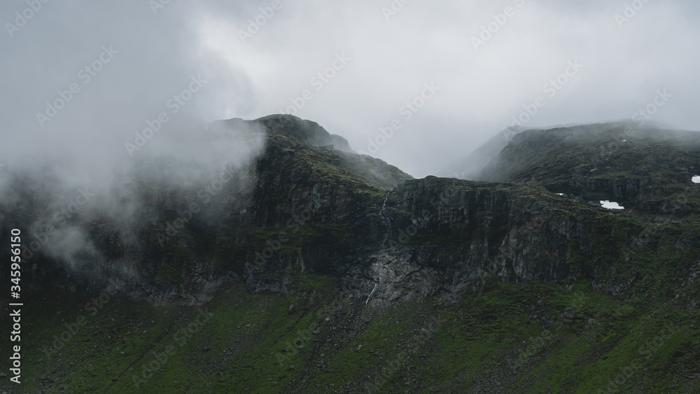 Fototapeta premium clouds rolling in over mountain tops during a hike in Norway