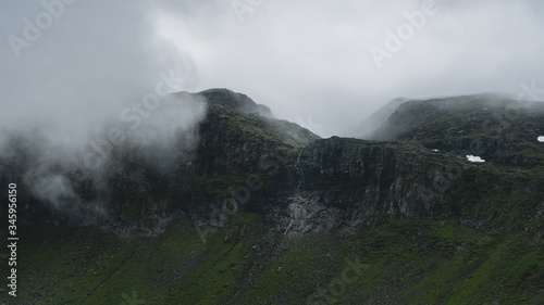 clouds rolling in over mountain tops during a hike in Norway