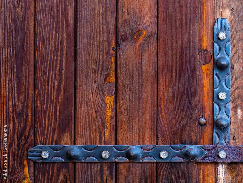 Down an old wooden door with rusty metal hinges Down an old wooden door with rusty metal hinges