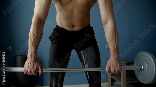 handsome guy execising with barbell in a living room photo