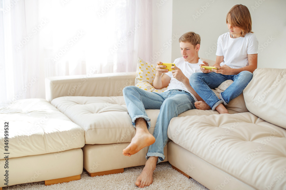 Children teenagers play a game on the phone at home. Children teenagers play a game on the phone at home.