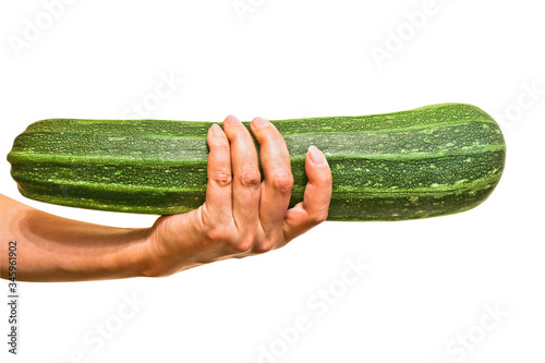 Fresh green zucchini in a female hand. Healthy vegan food. Isolated. Close-up.
