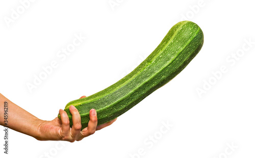 Fresh green zucchini in a female hand. Healthy vegan food. Isolated. Close-up.