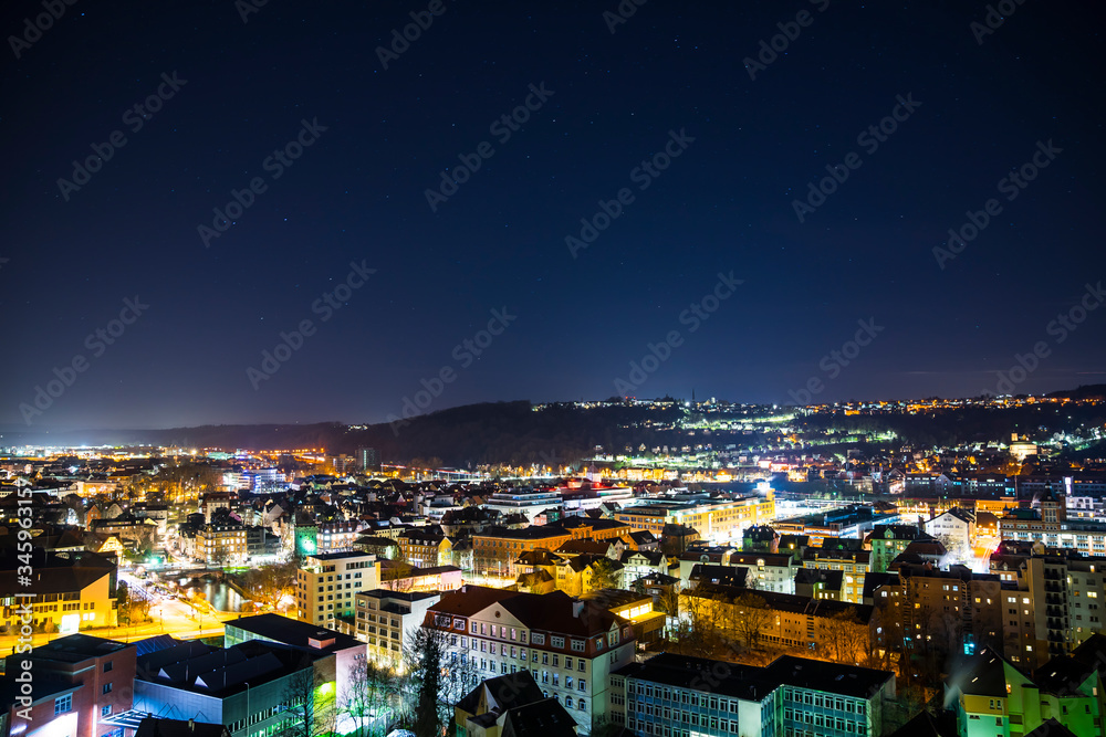 Obraz premium Germany, Dark starry sky over old town buildings of medieval city esslingen am neckar, aerial view above the houses and roofs by night