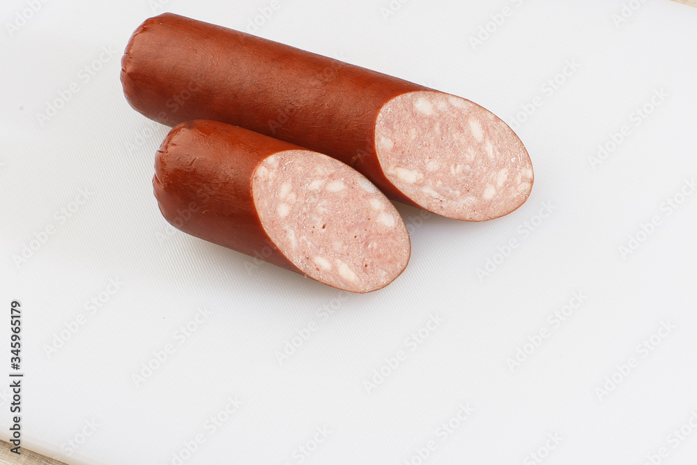 Industrial manufacture of sausages. Smoked sausage on a wooden rustic table with addition of fresh aromatic herbs and spices, natural product from organic farm, produced by traditional methods. Industrial manufacture of sausages. Smoked sausage on a wooden rustic table with addition of fresh aromatic herbs and spices, natural product from organic farm, produced by traditional methods.