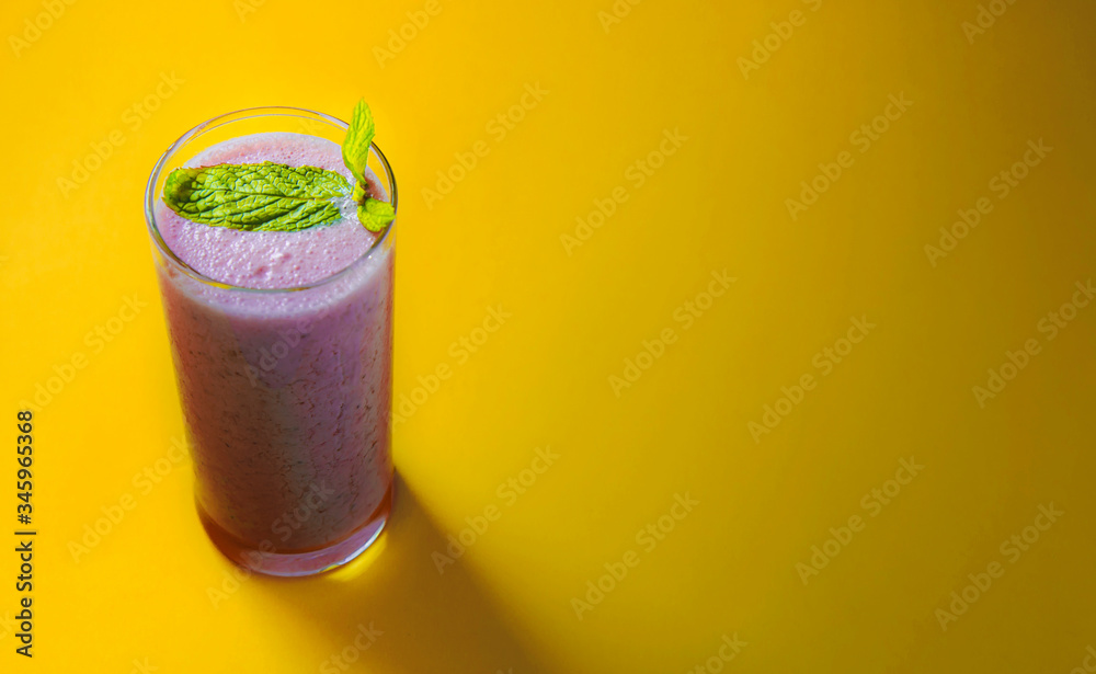 Minimal view of strawberry smoothie over pastel yellow background, copy space Minimal view of strawberry smoothie over pastel yellow background, copy space
