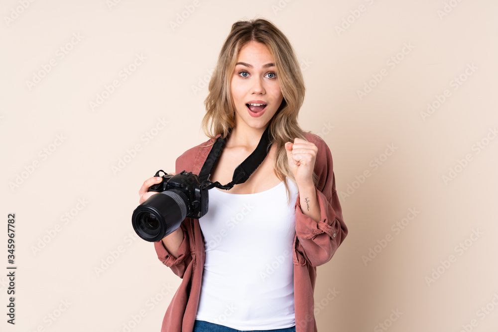 Obraz premium Young photographer girl over isolated background celebrating a victory in winner position