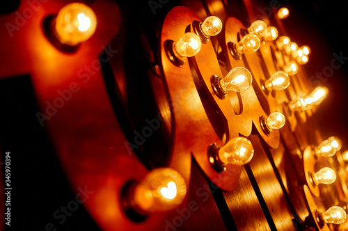 Cozy, lamp lighting in an institution on a wooden wall.Glass bulbs hanging on the ceiling shine and warm light.