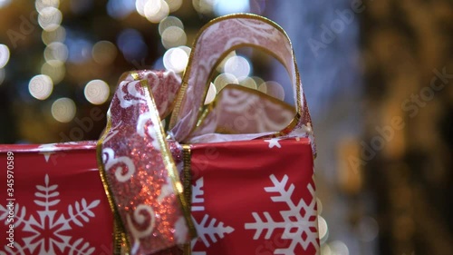 Gift Bag presents Christmas near Fireplace. Decorative Snowflakes wrapped box. Closed ribbon decorative bow. Isolated close-up.
 photo