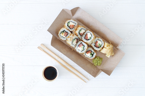 Japanese sushi to go. Biodegradable take away craft box with sushi maki rolls california. Asian food with smoked eel, avocado, cucumber and red caviar. Healthy snack delivery