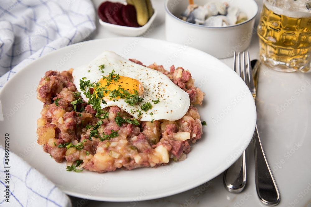 Norddeutscher Hamburger Labskaus mit Rindfleisch Corned Beef, Rote Beete, Kartoffeln, Saure Gurken, Spiegelei, Rollmops und Bier auf Marmor Norddeutscher Hamburger Labskaus mit Rindfleisch Corned Beef, Rote Beete, Kartoffeln, Saure Gurken, Spiegelei, Rollmops und Bier auf Marmor
