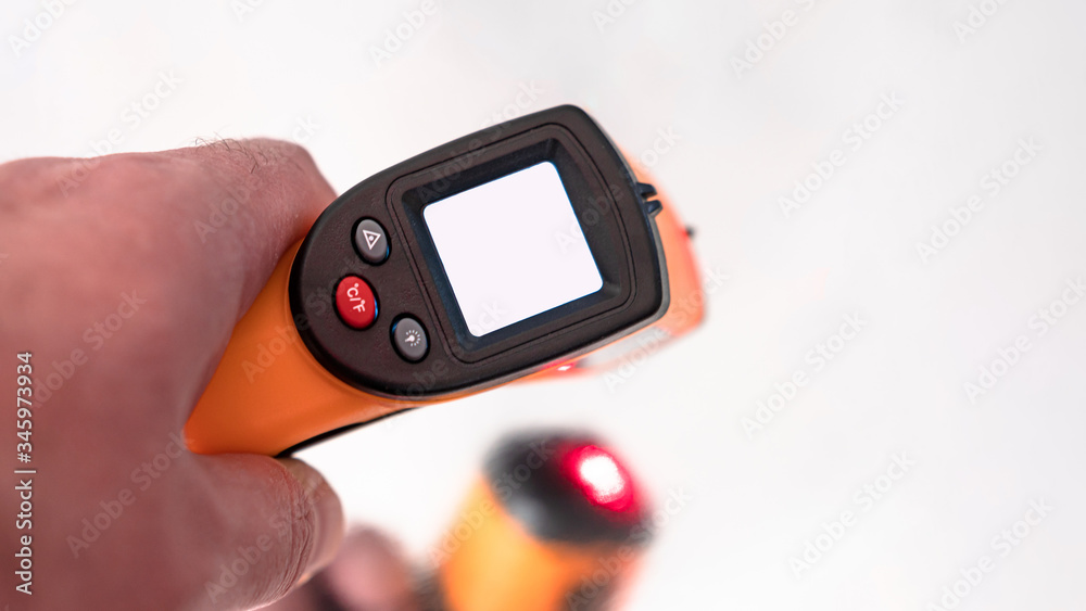 Fototapeta premium Remote electronic thermometer in hand with white screen.