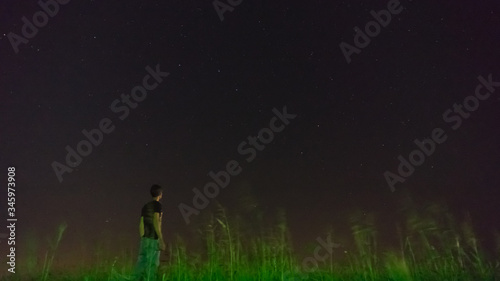 Man stands in the field at night in the starry sky background, Blagoveshenskaya village, Anapa, Russia.