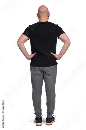 rear view of a man with sportswear on white background, arms on hip © curto