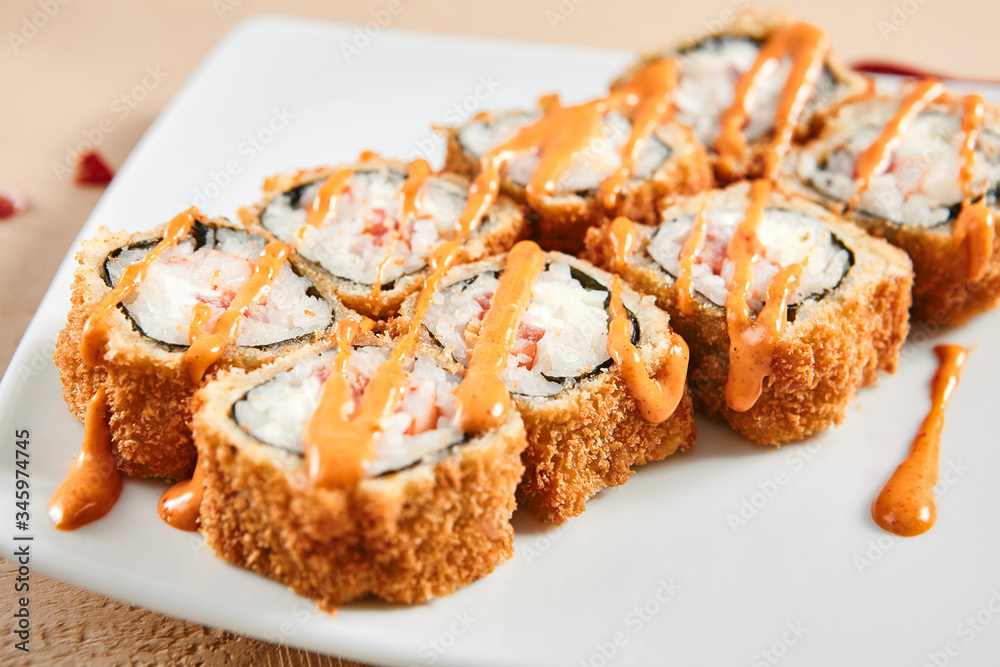 Rolls with shrimps, cream cheese, tomatoes and Spicy sauce in white plate top view