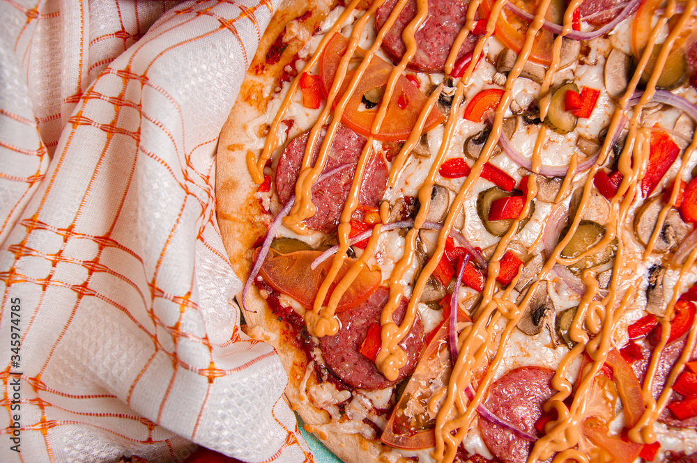 Pizza with various ingredients on checkered fabric. Photo for the menu