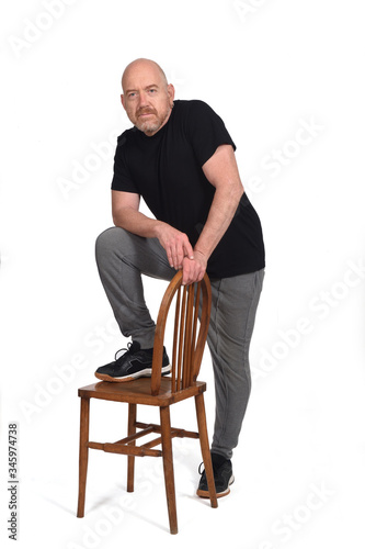 man standing with a chair in white background