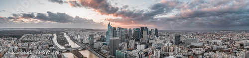 Panoramic aerial drone shot of la defense skyscraper complex with clouds during sunset hour © Davidzfr