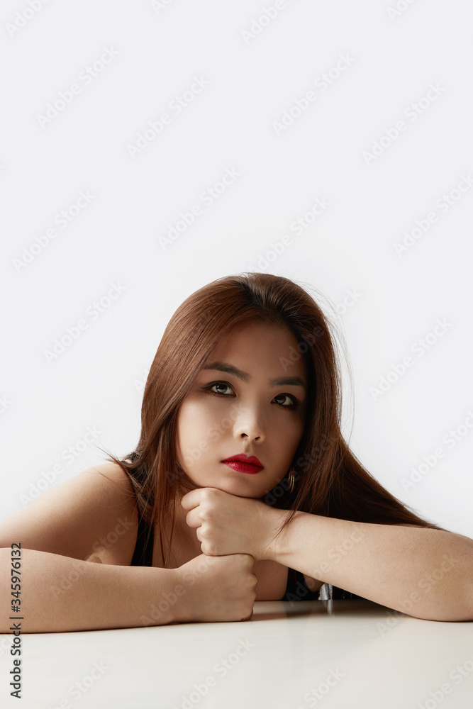 Vertical portrait of beautiful asian woman with long hair posing in studio on white studio background. Isolated. Vertical portrait of beautiful asian woman with long hair posing in studio on white studio background. Isolated.