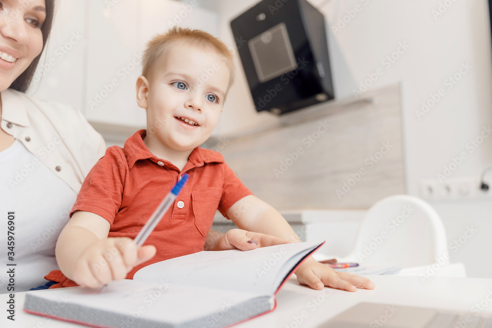 Mother teaching her kid son how to write pen. concept Online learning quarantine Mother teaching her kid son how to write pen. concept Online learning quarantine