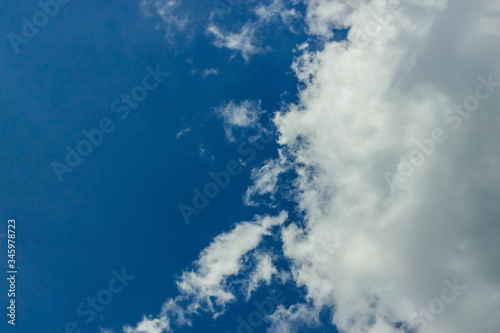 Fluffy white clouds float in the blue sky. Divine view. Background for the concept regard, consideration, respect, esteem, deference, reverence, homage. copy space