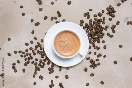 Cup of coffee cappuccino with coffee beans on a table vintage background