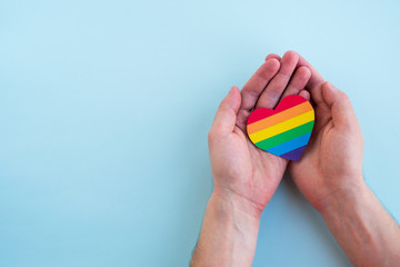 LGBT rainbow heart in man hands. Pride month, love and tolerance concept. Top view, copy space