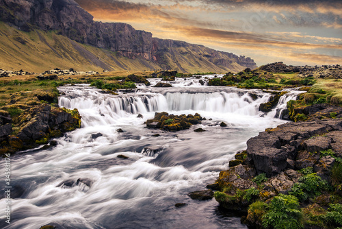 Fantastic Sunset in Iceland. Wonderful nature landscape with powerful river and waterfall. Typical Icelandic scenery