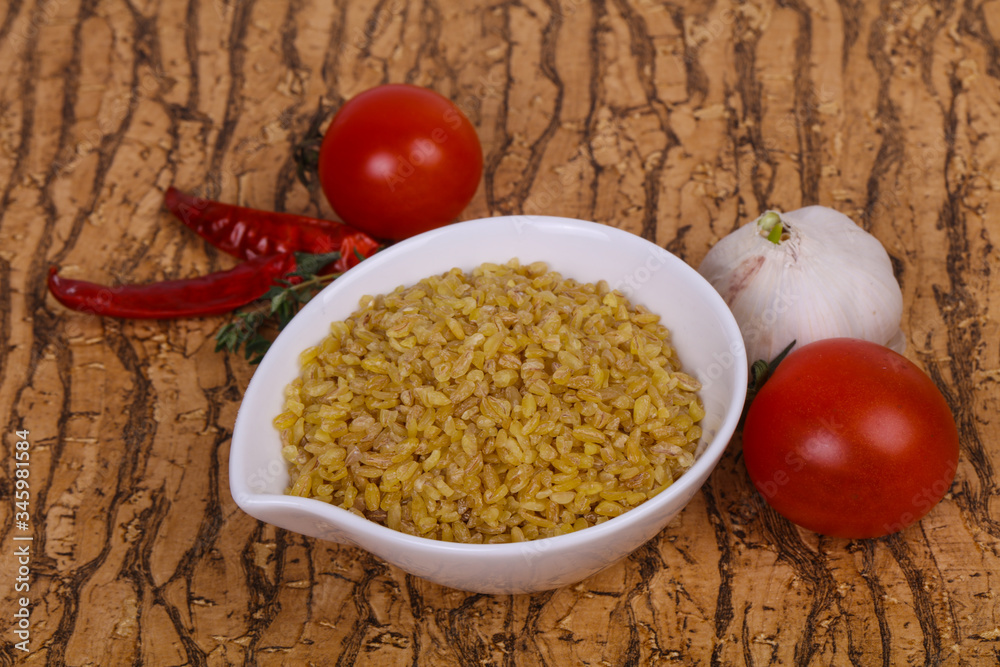 Raw bulgur in the bowl with tomatoes and garlic Raw bulgur in the bowl with tomatoes and garlic