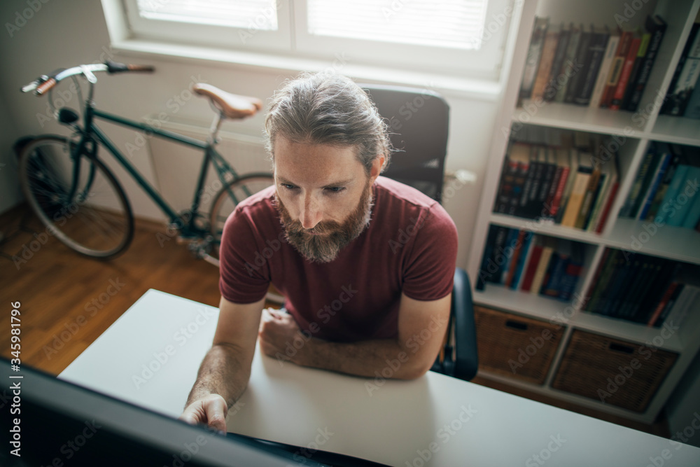 Fototapeta premium Bearded man working form his home office desk