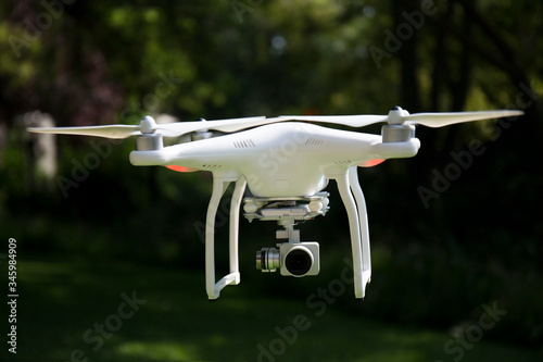 Flying white professional quadcopter drone camera