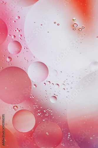 Fond de bulles abstraites - huile dans l'eau sur un arrière-plan flou dans des tons rose rouge