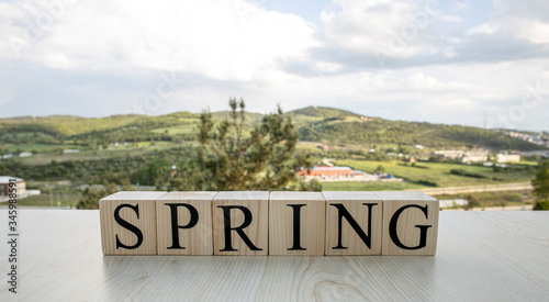 Spring, text on wooden cubes on rusty white painted iron.