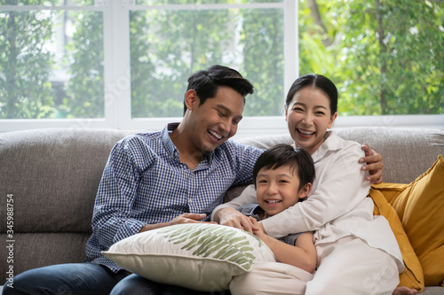 portrait of happy Asian family spending time together on sofa in living room. family and home concept.